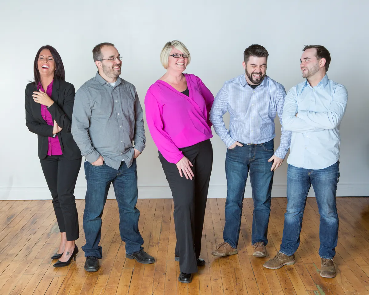 Five members of the Triton team laughing together