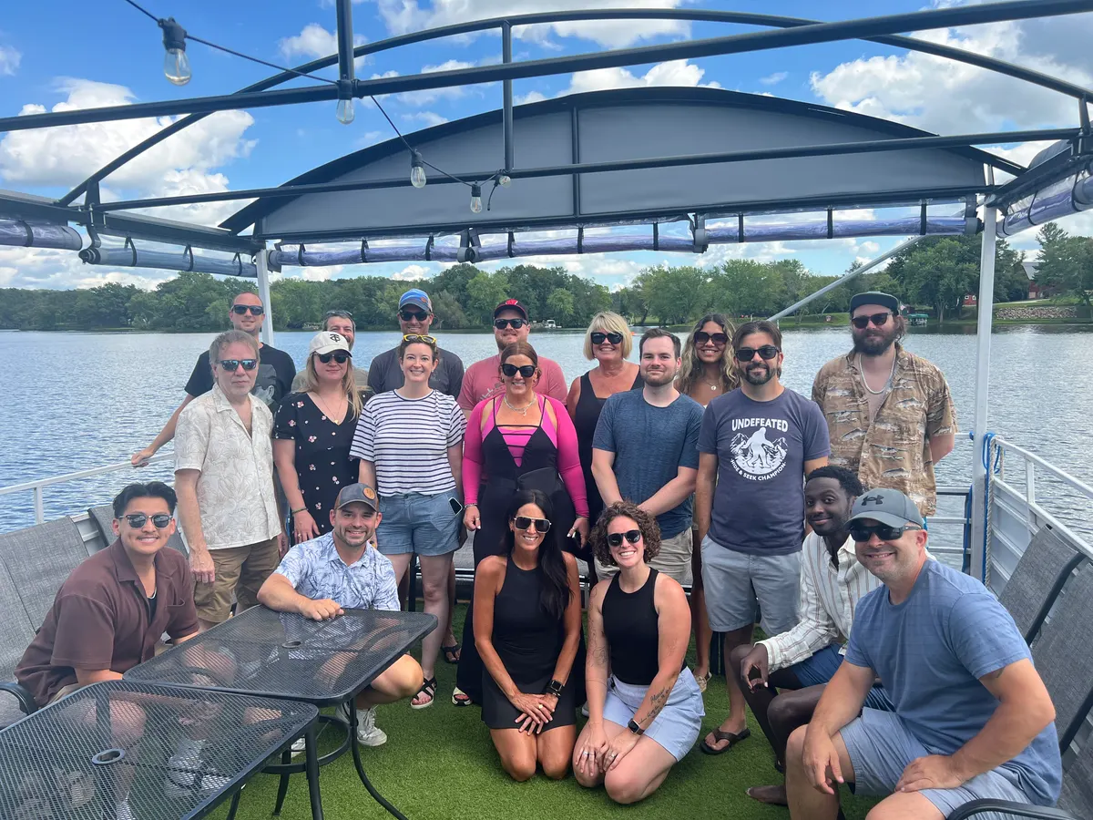 The Triton Commerce team gathered together on a pontoon boat on a Minnesota lake