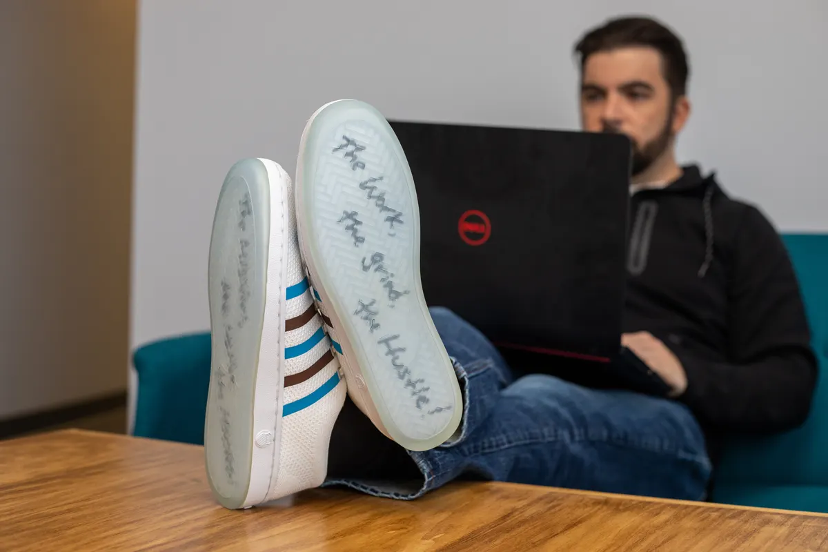 A Triton team member working on a laptop with his feet kicked up on the desk